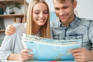 couple holding a map choosing a place to spend their spring vacation