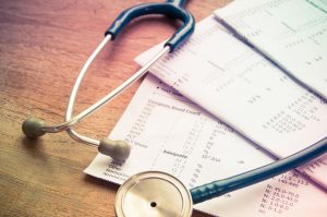 stethoscope and laboratory result sheet used during medical consultation