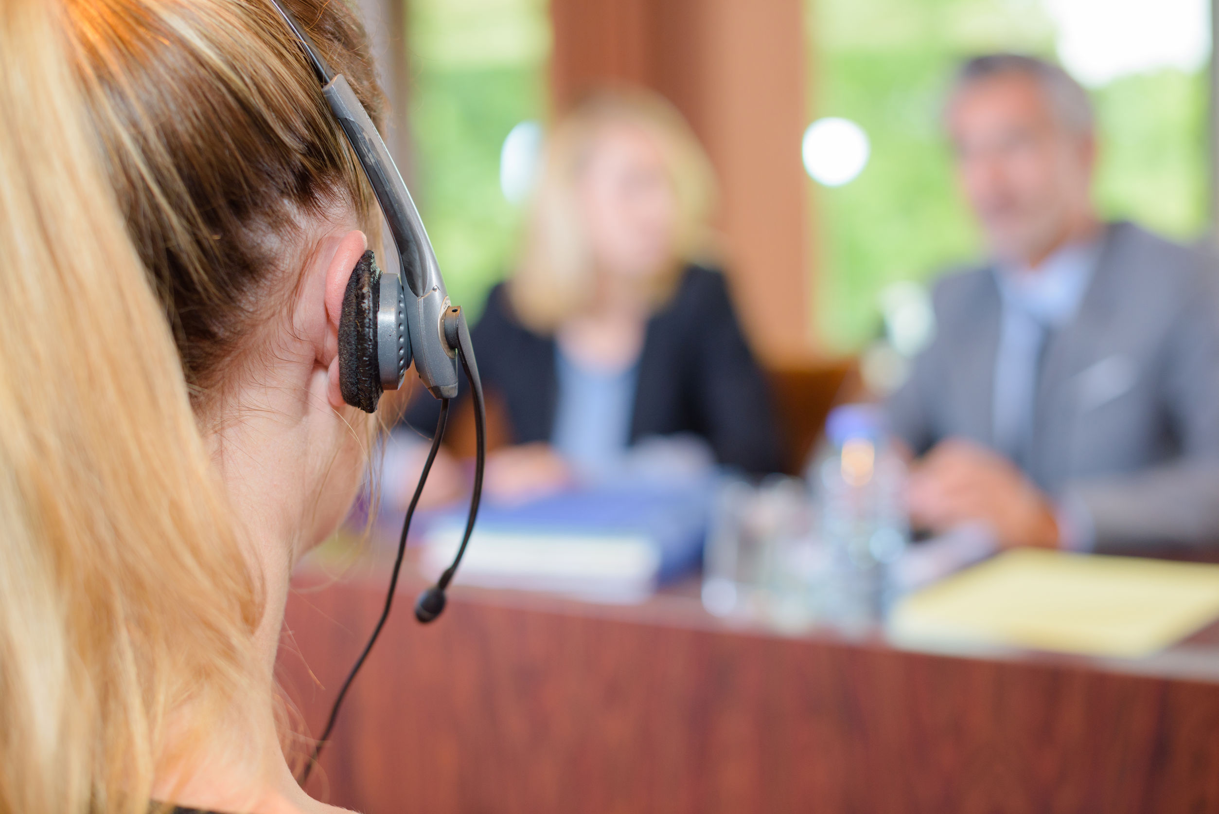 Business Interpreter wearing a head set in a corporate meeting