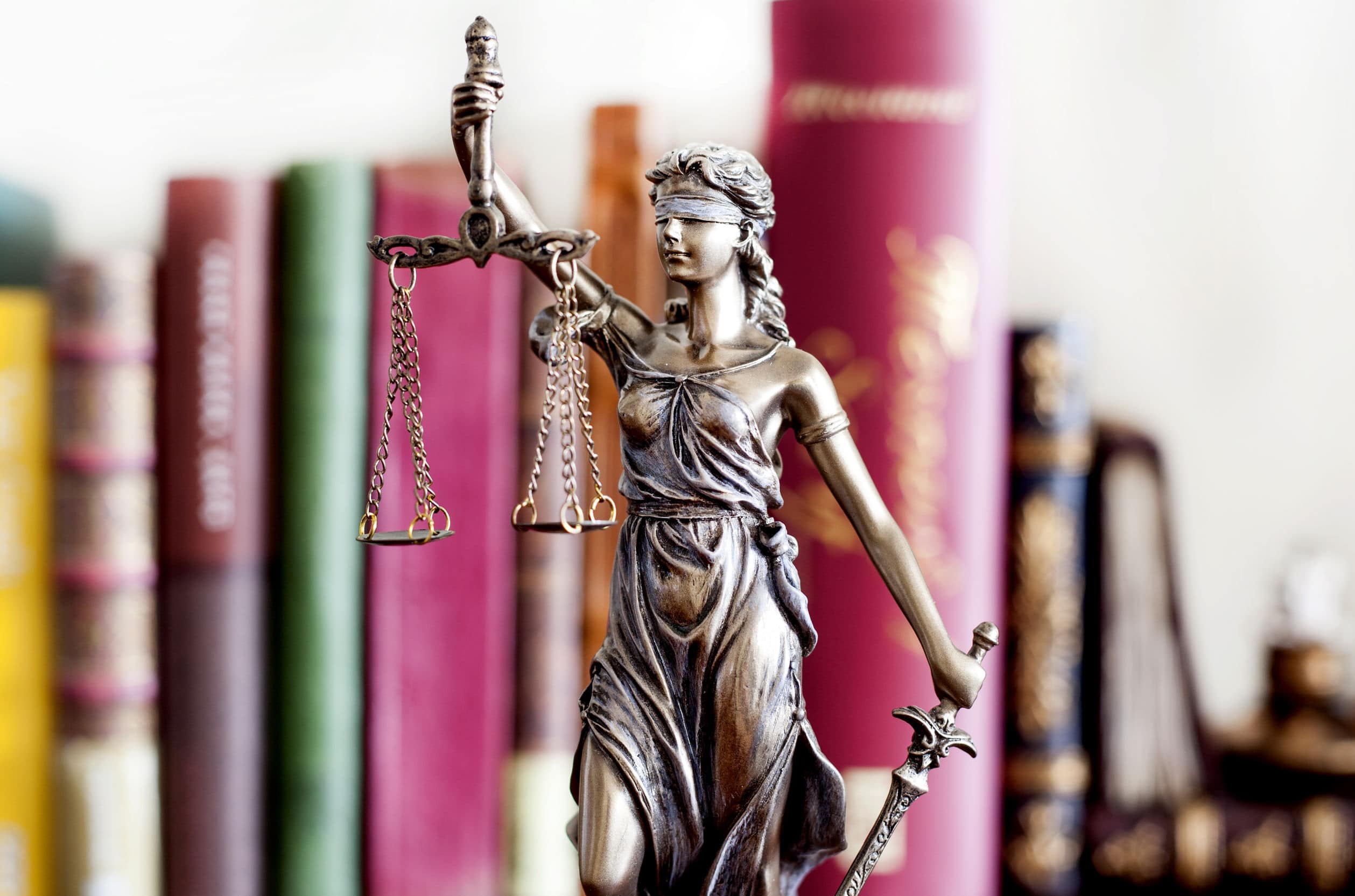 statue of justice in front of books for legal translation