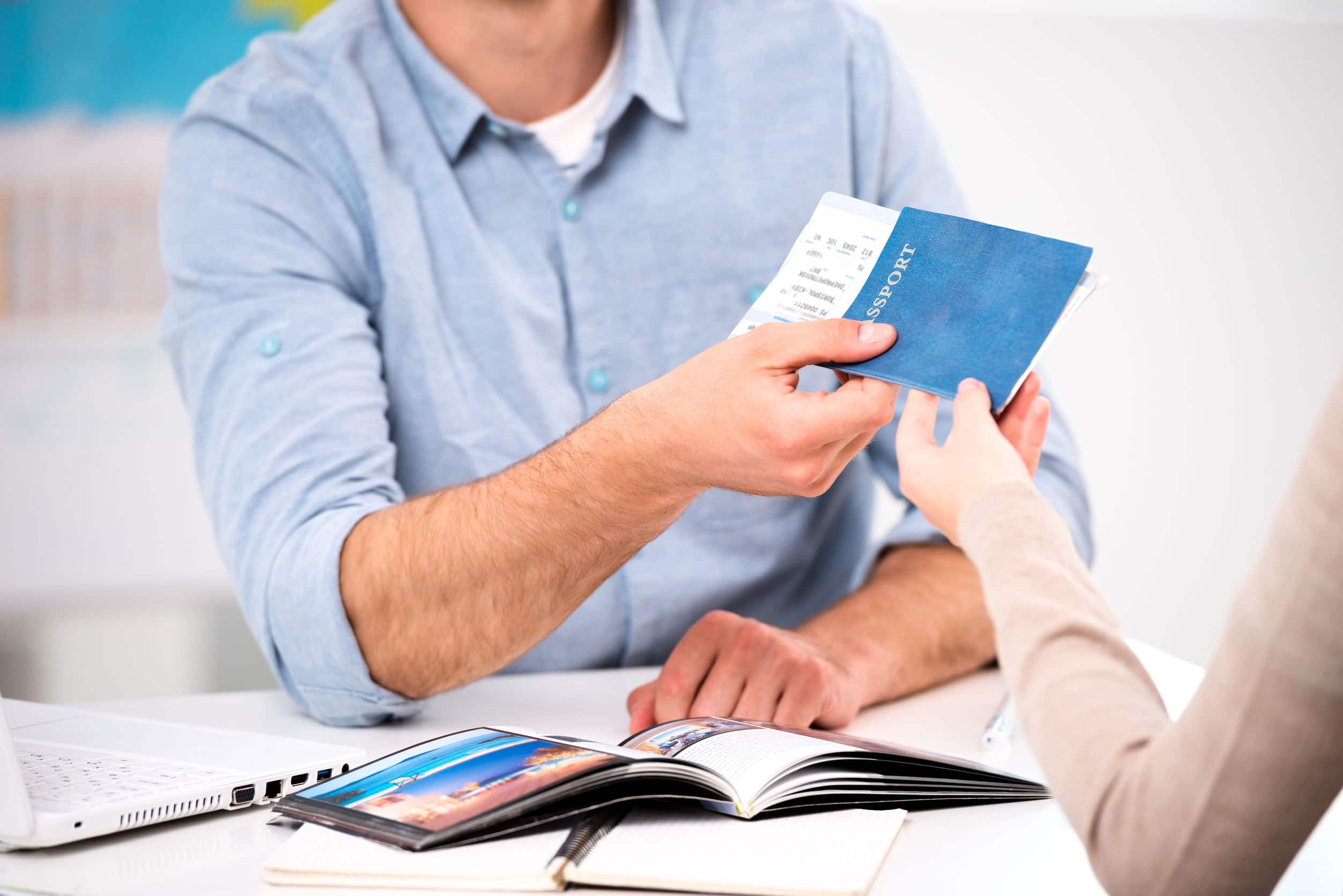 man handing over his passport and plane ticket to a lady